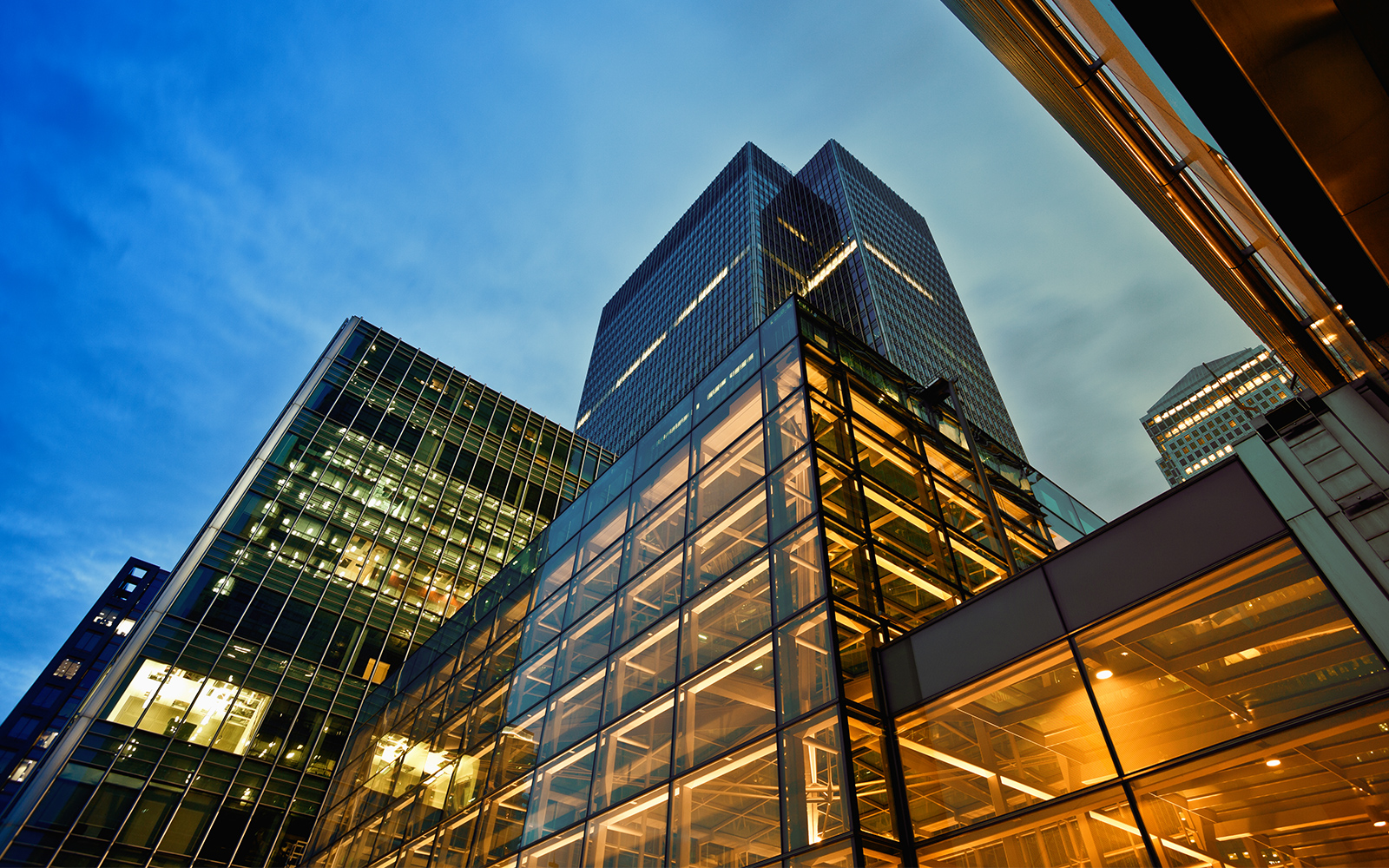 A view from the ground up of an office building lit up at night