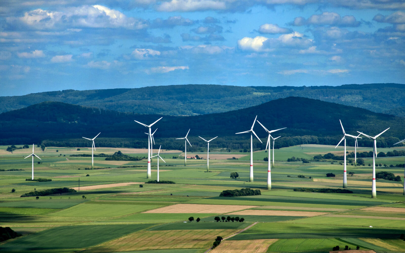 A view of a wind farm in front of mountains