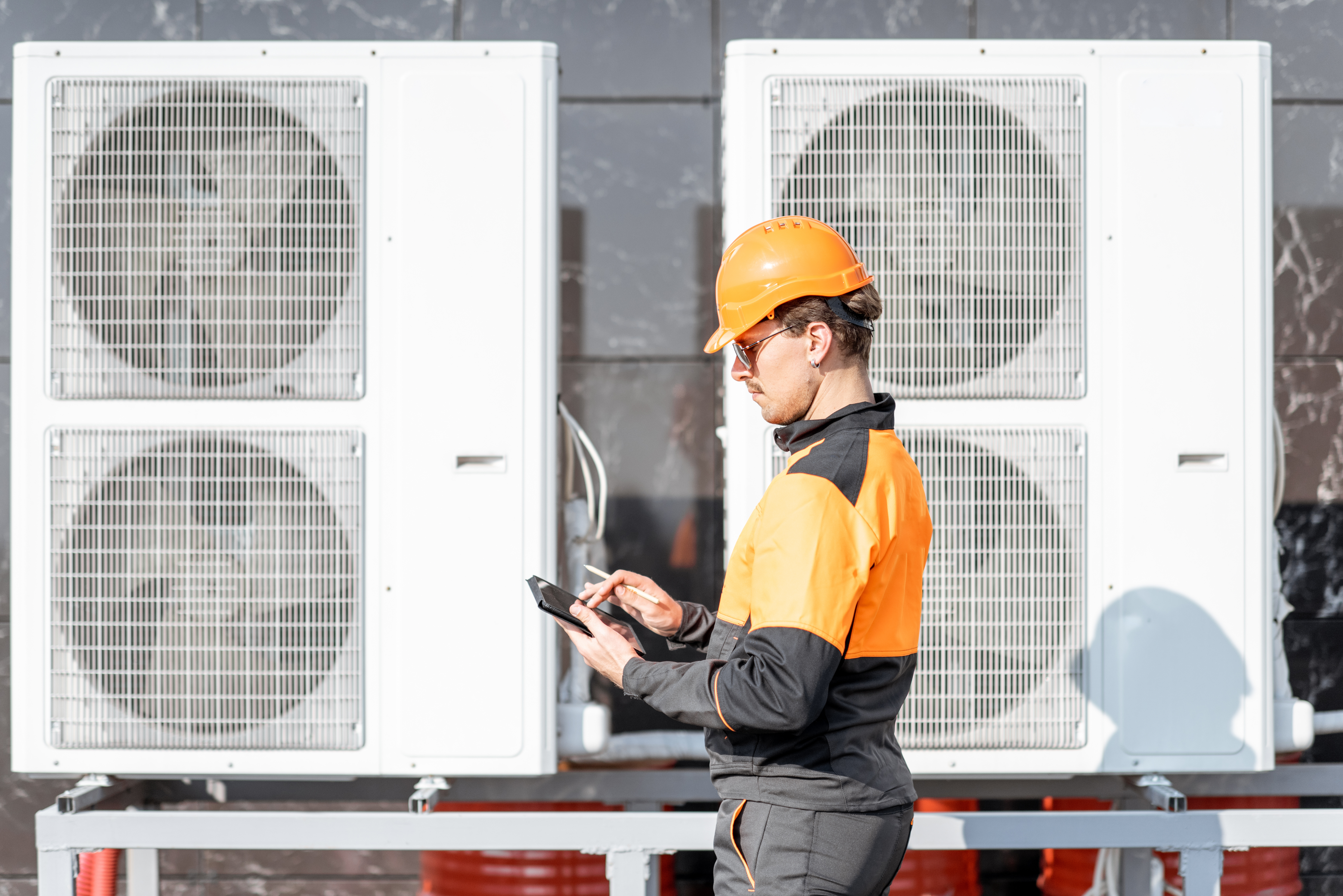 Man carrying out checks for servicing various large heat pumps 