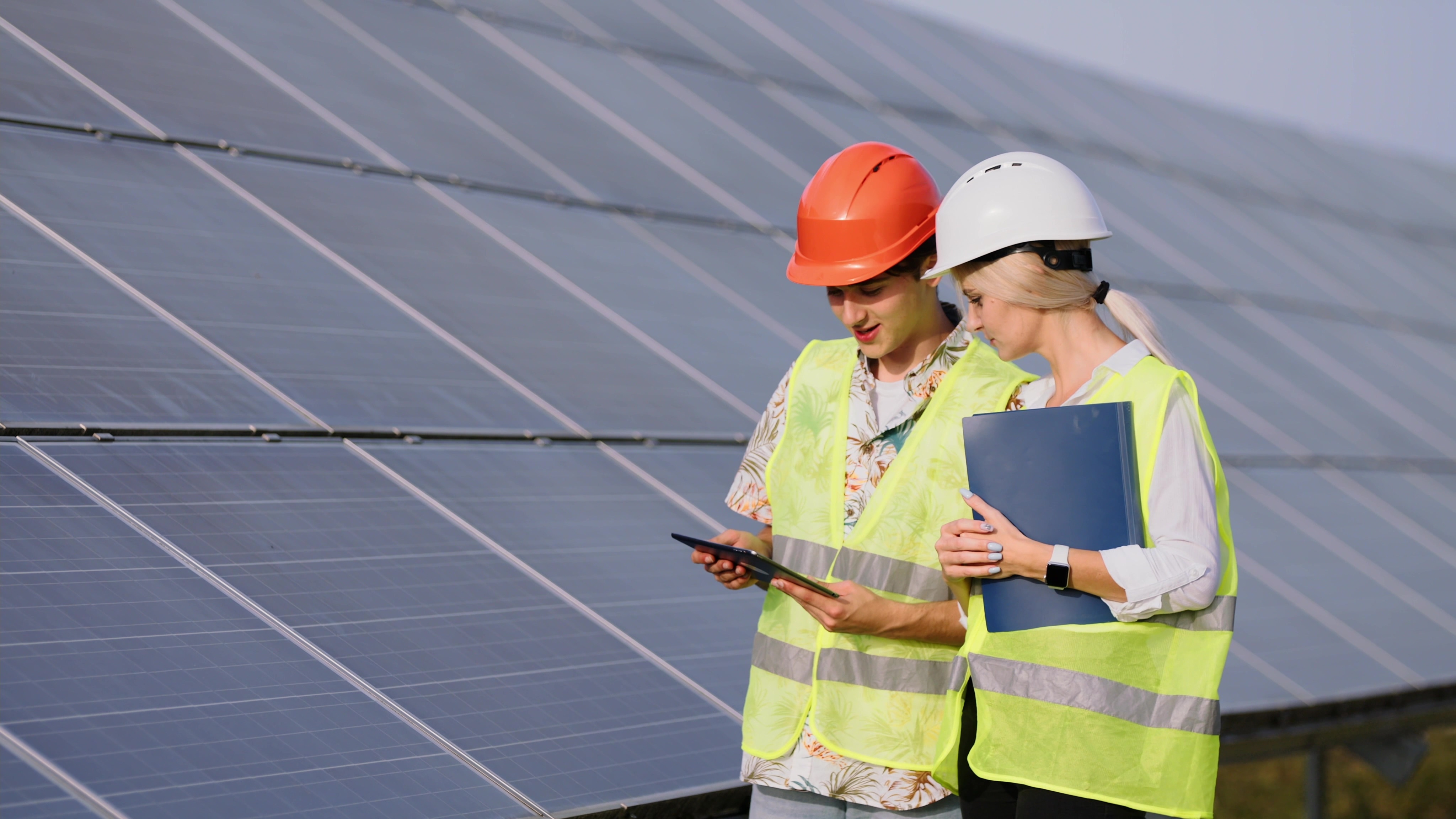 Two females in hi-viz and hard hats on a site visit to a solar farm