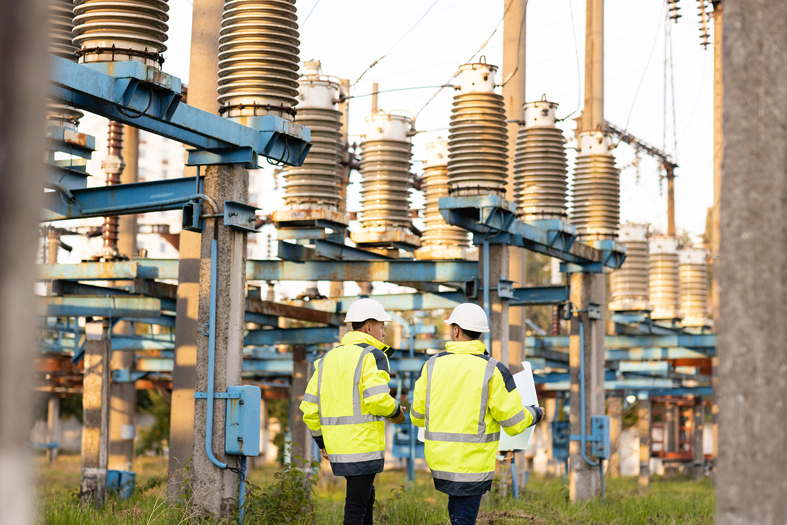 Energy Workers Walking Within Substation Complex