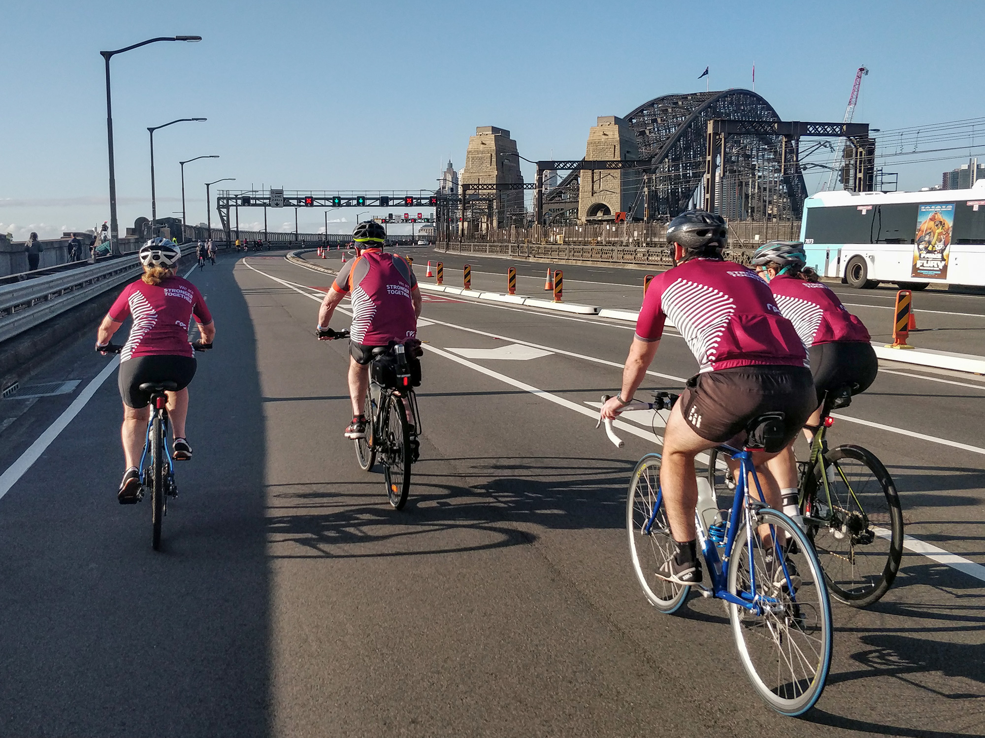 RPS team members cycle over the Sydney Harbour Bridge wearing branded T-shirts