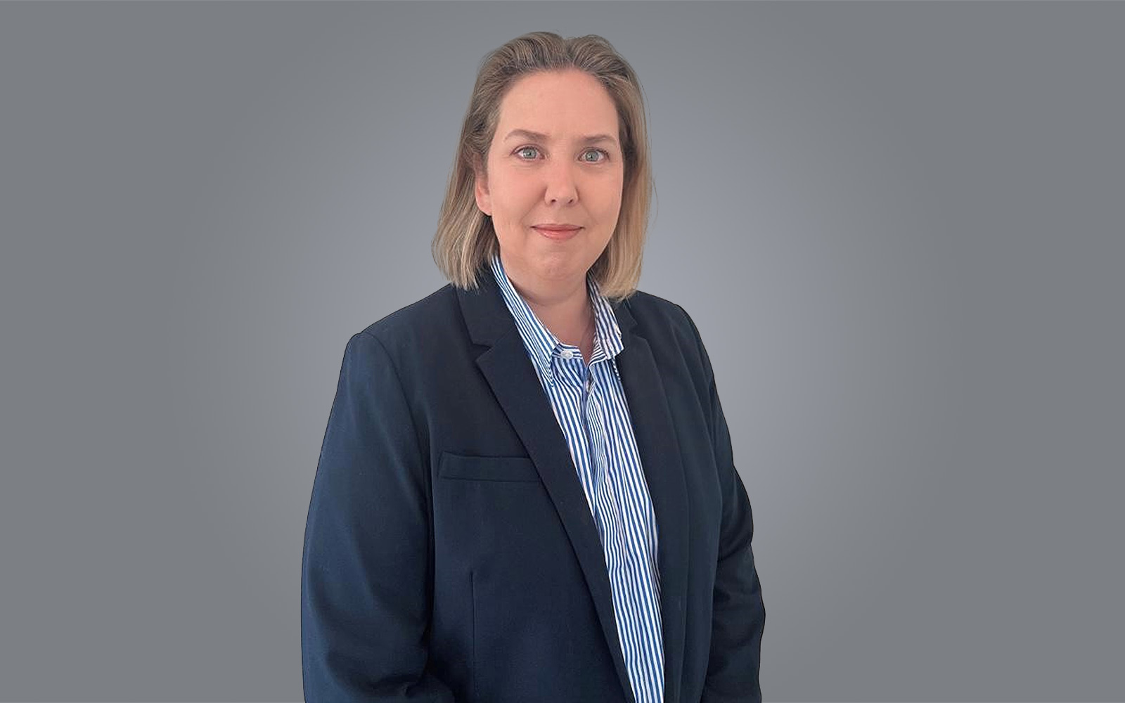 Kim Drubbel, Director - Strategy & Investment, RPS, wears blue suit and shirt in Perth office,