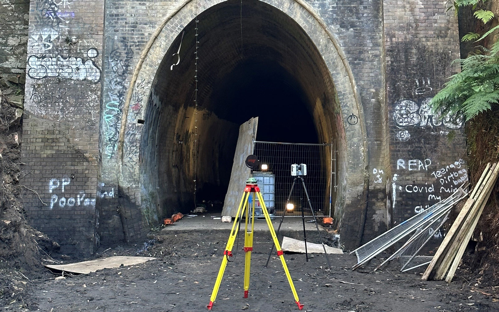 Outside the Lapstone Hill Tunnel, which shows signs of graffiti - and surveying equipment perched on entry.  