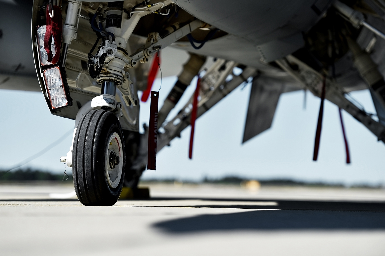 Defence sector expertise RPS 
Image: close up of jet landing gear and underside of fuselage of aircraft parked on an Air Force base.