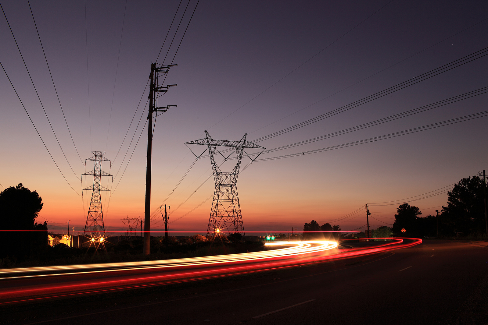 Power transmission lines and road infrastructure at sunset